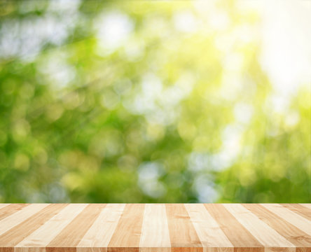 Wooden tabletop with fresh green nature blurred background