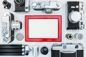 old retro cameras, roll films, tripod and red photo frame for old memories concept design