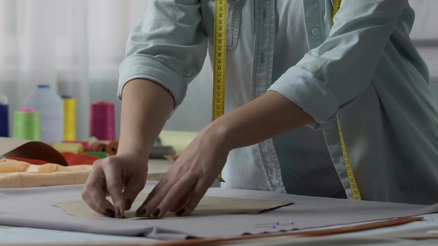 Dressmaking class teacher demonstrating to attach patterns by pins, occupation