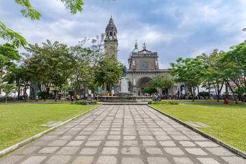 Fototapeta na wymiar Tourists and cataclysmic tourists visiting the Manila Cathedral Gardens