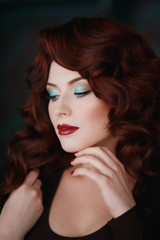 Fototapeta premium Portrait of beautiful redhead young girl with red lipstick. Concept person for a glossy magazine, model, eyes closed