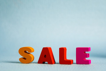 Sale colorful wooden text on blue background with copy space, shopping discount and marketing concept. template for add text or photo.