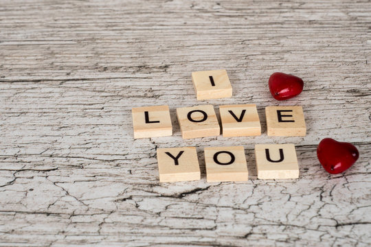 i love you letters and two hearts on white rustic wooden table