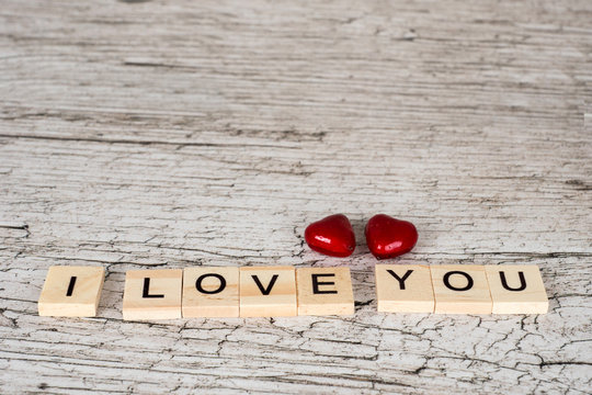 i love you letters and two hearts on white rustic wooden table