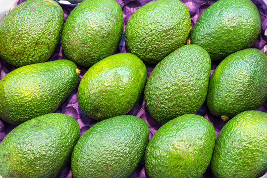 Bunch of ripe green avocados for sale at a market