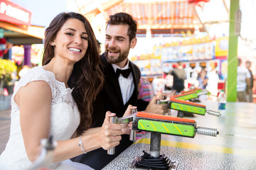 Just married couple playing games at fair carnival amusement park