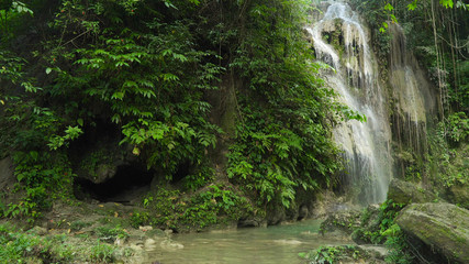 Waterfall in green forest in jungle. Beautiful waterfall in the mountains. Tropical rain forest with waterfall. Philippines, Cebu. Travel concept.