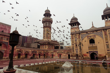 Fototapeta na wymiar More than 4 century old Mosque at Lahore in all of its glory . The Pigeons adding the beauty to the culture of the mosque.