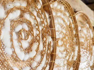 Foto op Canvas Close-up detail of silkworm cocoons on multiple circular woven bamboo trays, at a local textile mill. Nakhon Ratchasima, Thailand. Travel and textile cottage industry concept. © substancep