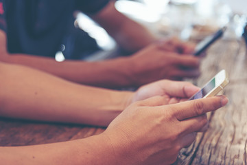 Selected focus on  man hand, relaxed using smart phone and digital tablet at coffee shop. Young man browsing on smart phone in interior building. E-business internet of things concept. Freelance
