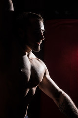 Silhouette of muscular man on dark red background