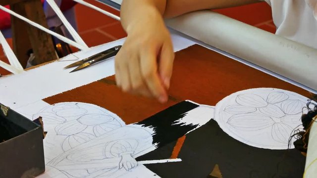 Close up of a person doing hand-stitching Vietnam embroidery on the fabric.