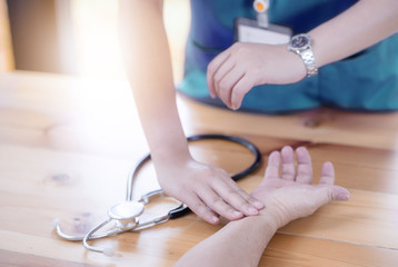 Obraz na płótnie Canvas Cropped image of nurse checking patience's pulse