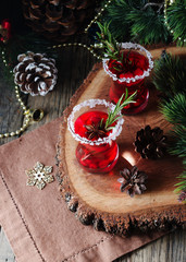 glass of hot mulled wine for the new year with ingredients for cooking, nuts and Christmas decorations
