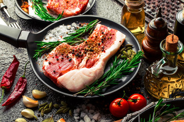 Raw meat on the kitchen table on a metallic background in a composition with cooking accessories