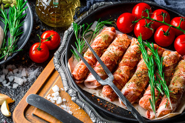 Raw meat on the kitchen table on a metallic background in a composition with cooking accessories