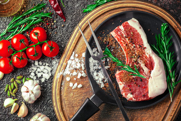 Raw meat on the kitchen table on a metallic background in a composition with cooking accessories