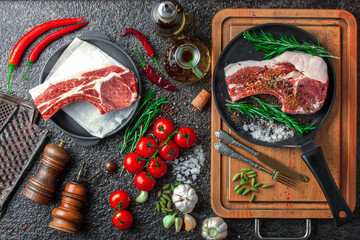 Raw meat on the kitchen table on a metallic background in a composition with cooking accessories
