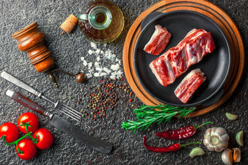 Raw meat on the kitchen table on a metallic background in a composition with cooking accessories