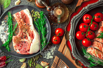 Raw meat on the kitchen table on a metallic background in a composition with cooking accessories