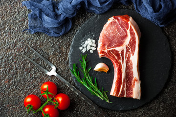 Raw meat on the kitchen table on a metallic background in a composition with cooking accessories