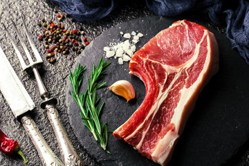 Raw meat on the kitchen table on a metallic background in a composition with cooking accessories