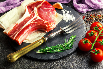 Raw meat on the kitchen table on a metallic background in a composition with cooking accessories