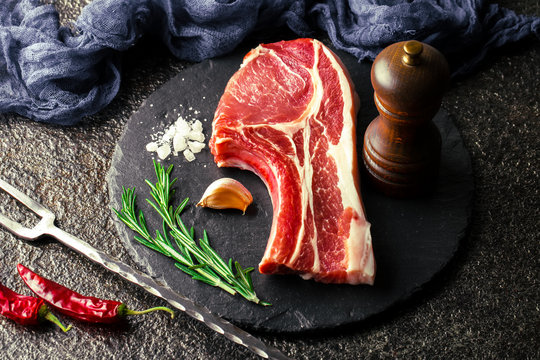 Raw meat on the kitchen table on a metallic background in a composition with cooking accessories