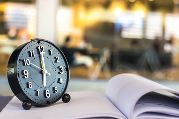 Notepad with pencil and clock on wood board background.using wallpaper for education, business...