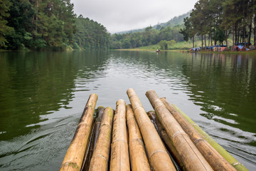Rafting with wooden raft in the lake of forest hill, Journey in Thailand