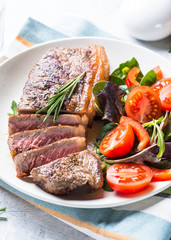 Grilled beef striploin steak with fresh salad.