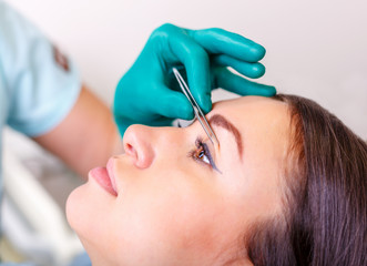 Cosmetic surgeon examining female client in clinik  before plastic surgery. Blepharoplasty