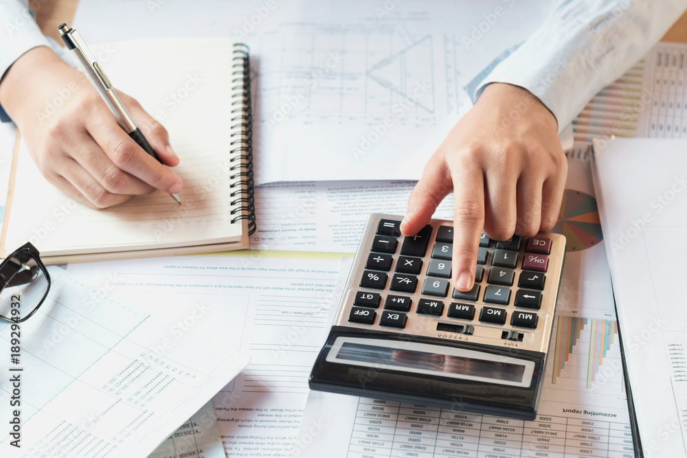 Poster accountant working on desk to using calculator with pen on book .concept finance