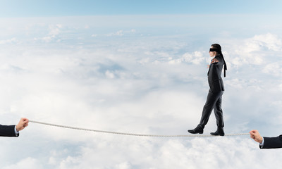 Obraz premium Business concept of risk support and assistance with man balancing on rope