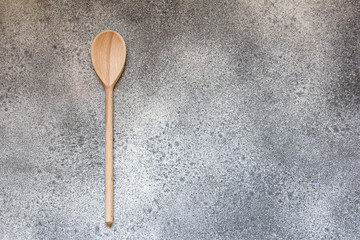 Wooden kitchen spoon on gray concrete style.