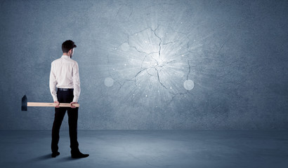 Business man hitting wall with a hammer