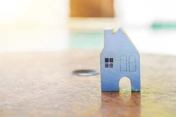 Obraz na płótnie Canvas Miniature wooden blue house on old wooden chinese compass over blurred background, property object concept