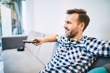 Relaxed man watching tv at living room
