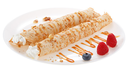 Serving pancakes with  blueberry, raspberry and whipped cream on the plate. Decorated with caramel syrup. Isolated on white background.
