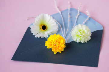 Flowers in a blue envelope on a pink background