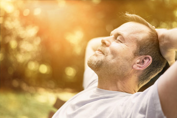 Mann entspannt in der Sonne - genießt Freizeit - macht Power Napping