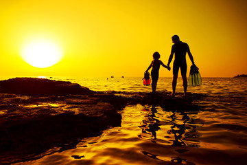 Father and daughter hand in hand on the rock, Croatian cost, seaboard.