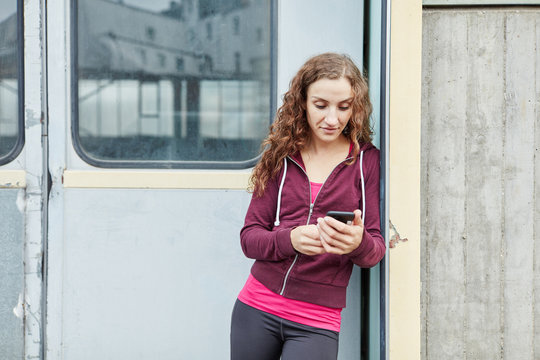 Junge Sportlerin mit Smartphone