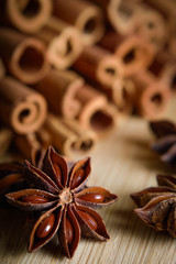  shelves of cinnamon and anise stars in dark backgrounds on a wooden background