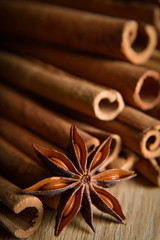  shelves of cinnamon and anise stars in dark backgrounds on a wooden background