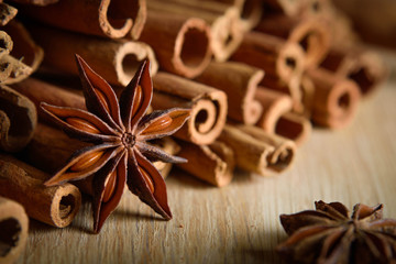  shelves of cinnamon and anise stars in dark backgrounds on a wooden background