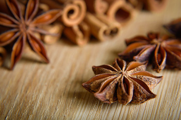  shelves of cinnamon and anise stars in dark backgrounds on a wooden background