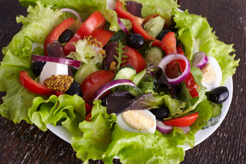 salad from fresh vegetables in a plate on a table, selective focus