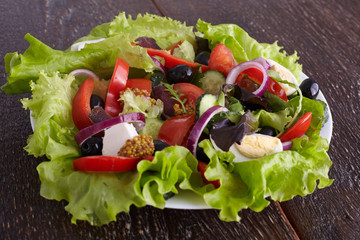 salad from fresh vegetables in a plate on a table, selective focus