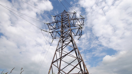 High voltage post.High-voltage tower sky background. High-voltage electrical insulator electric line against the blue sky. Electricity transmission power lines.